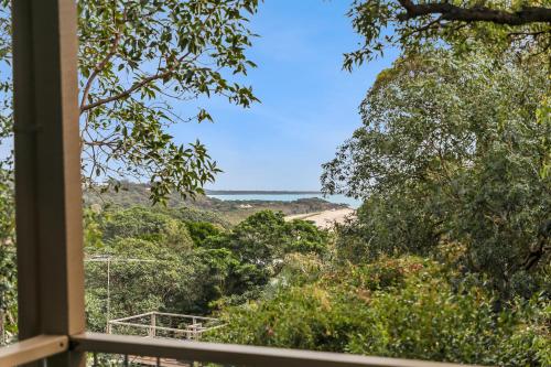 a view from the window of a house with trees and a beach at Home View 10B Yarrong in Point Lookout