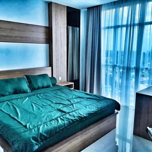 a bedroom with a green bed and a large window at SLEPTOPIA at Formosa Residence - Apartment 70m2 with Best interior & View in town in Nagoya