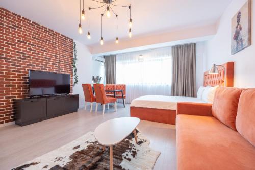 ein Hotelzimmer mit einem Bett, einem Sofa und einem TV in der Unterkunft Prima by the River in Oradea