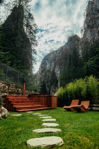 a walkway with a bench and stepping stones in the grass at Casa Cheile Dâmbovicioarei - Cabana 2 in Dîmbovicioara