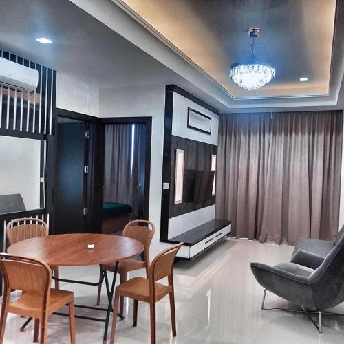 a living room with a table and chairs and a television at SLEPTOPIA at Formosa Residence - Apartment 70m2 with Best interior & View in town in Nagoya