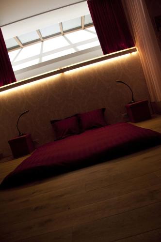 a bedroom with a red bed with a window at Schopenhauer in Ghent