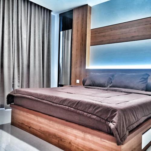 a bedroom with a bed with a wooden headboard at SLEPTOPIA at Formosa Residence - Apartment 70m2 with Best interior & View in town in Nagoya