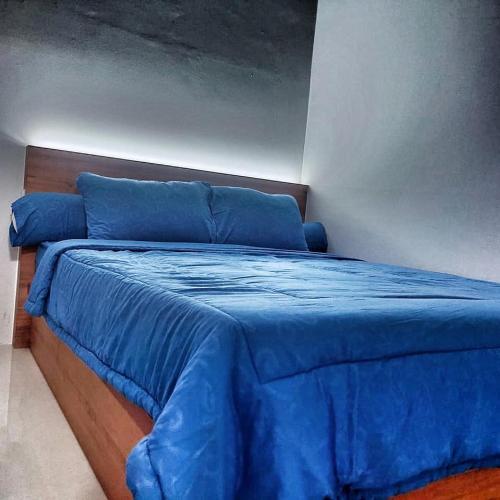 a blue bed with a blue blanket on it at SLEPTOPIA at Formosa Residence - Apartment 70m2 with Best interior & View in town in Nagoya