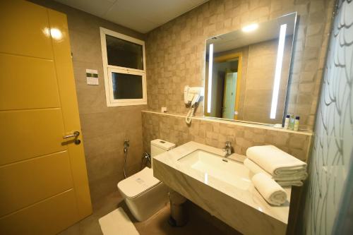 a bathroom with a sink and a toilet and a mirror at Emirates Stars Hotel Apartments Dubai in Dubai
