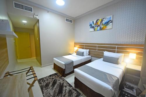a hotel room with two beds and a mirror at Emirates Stars Hotel Apartments Dubai in Dubai