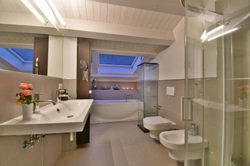 y baño con lavabo, aseo y bañera. en Villa Nausica pool view on the sea wifi free perfect for big group, en Ragusa