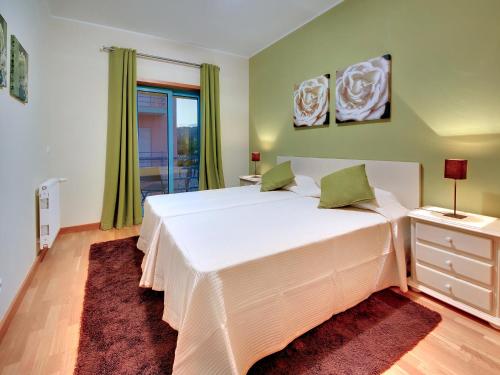 a bedroom with a large white bed and a window at Marina Sea Residence in Albufeira