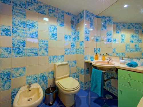 Baño de azulejos azules con aseo y lavamanos en Marina Sea Residence, en Albufeira