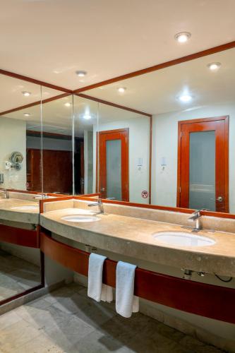 a bathroom with three sinks and a large mirror at Viva Maya by Wyndham, A Trademark All Inclusive Resort in Playa del Carmen
