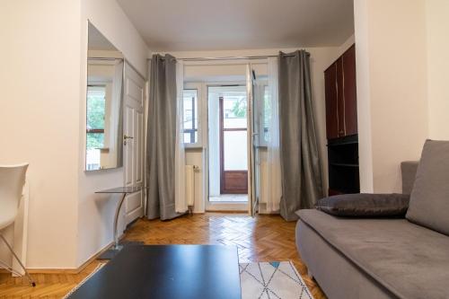 uma sala de estar com um sofá e uma mesa em Urban Nest Apartments Radziwiłłowska 12 em Cracóvia
