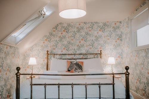 a bedroom with a bed with floral wallpaper at The Old Choir School in uphill Lincoln in Lincolnshire