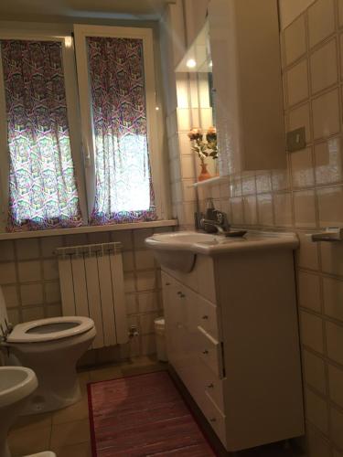 a bathroom with a sink and a toilet and a window at Affittacamere Ferranti tra Caserma e stazione in Foligno