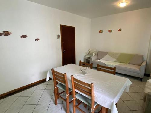 uma sala de estar com uma mesa e cadeiras e um sofá em Apto 2 dormitórios em Balneário Camboriú no Balneário Camboriú