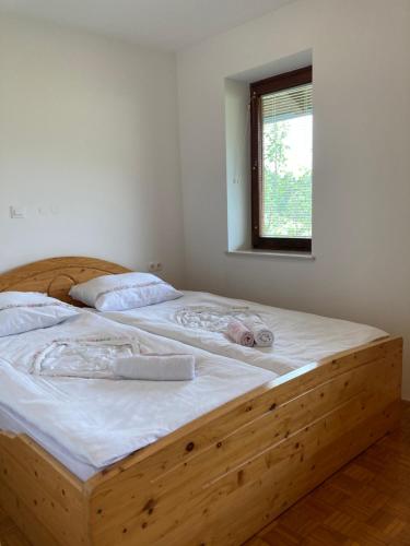 un letto in legno con asciugamani in una camera da letto di Apartment Vrtacnik a Štefanja Gora