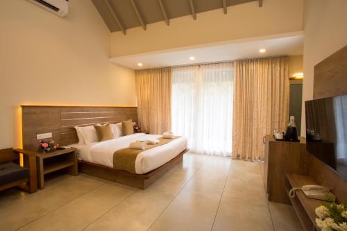 Letto o letti in una camera di Amrezy Resort and Spa by Stride, Wayanad