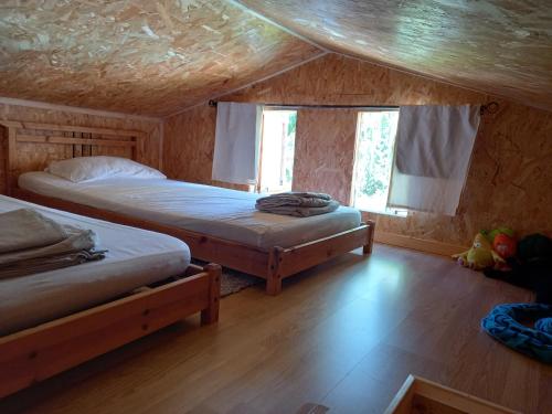 a bedroom with two beds in a log cabin at Casa di legnu ,charmant chalet avec piscine in Patrimonio