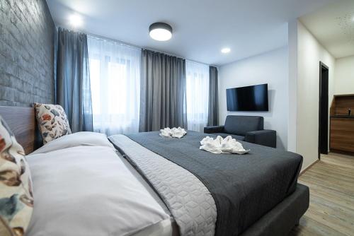 a bedroom with a large bed and a chair at Lidový dům Opava in Opava