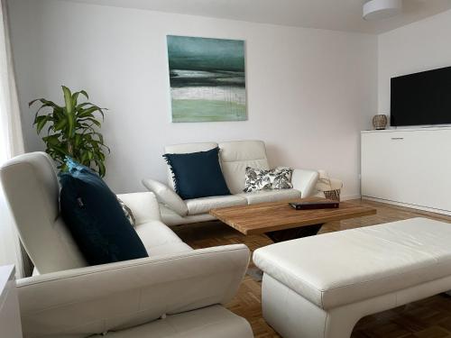 a living room with two couches and a flat screen tv at Hopfenglück in Tettnang