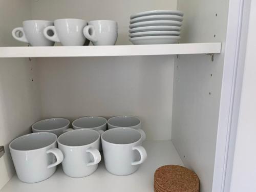 a row of cups and plates on a shelf at Hopfenglück in Tettnang