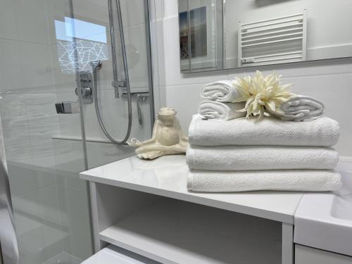 a pile of towels sitting on a shelf in a bathroom at Hopfenglück in Tettnang