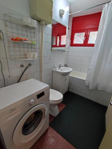 a bathroom with a washing machine and a toilet at Banjica 2 in Voždovac