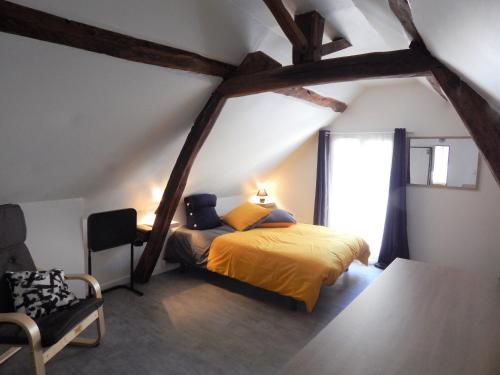 a bedroom with a yellow bed and a window at L'étonnante in Margny-lès-Compiègne