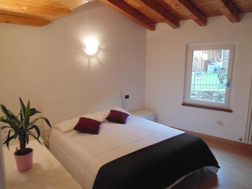 a bedroom with a bed with a plant in it at Cà Del Polsèt in Brenzone sul Garda