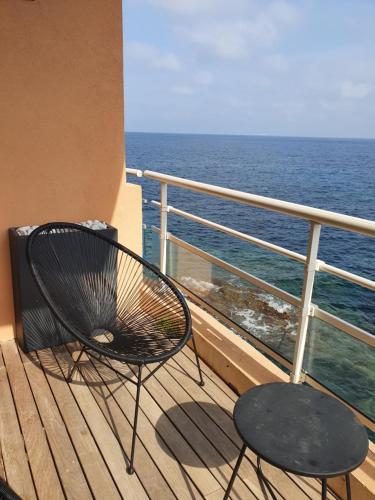 a chair and a table on a balcony with the ocean at studio un blacon sur la mer in Saint-Raphaël