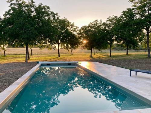 una piscina en medio de un campo con árboles en Clos du Palens Agen - Que des amis, que du bonheur, en Laugnac