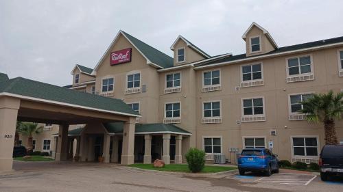 a hotel with a car parked in front of it at Red Roof Inn & Suites Midland in Midland