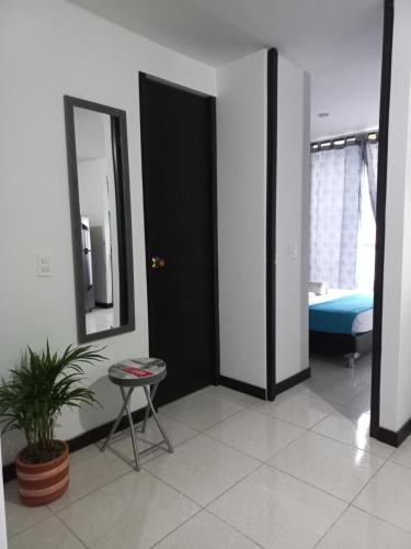 a room with a mirror and a table and a bed at aparta hotel turístico a 2 km parque del café in Montenegro