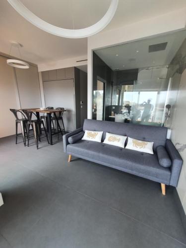 a living room with a blue couch and a table at studio un blacon sur la mer in Saint-Raphaël
