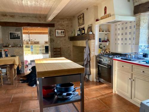 a kitchen with a stove and a table in it at Clos du Palens Agen - Que des amis, que du bonheur in Laugnac