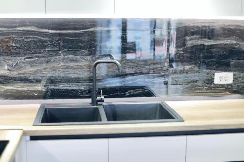 um lavatório de cozinha com uma torneira no balcão em Miku Apartment - Unique 3 Bedroom At Olympic Residence em Tirana