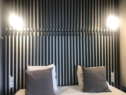 a bed with two pillows in front of a wall at Be On The Beach in Sainte-Anne