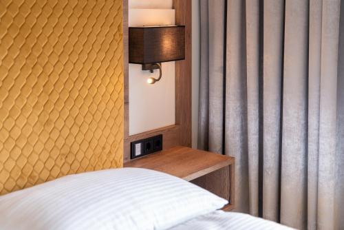 a bedroom with a bed and a headboard and a mirror at Hotel Traunfall in Viecht