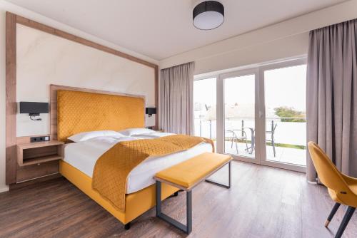 Habitación de hotel con cama y balcón en Hotel Traunfall, en Viecht