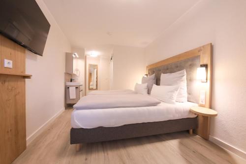 a hotel room with a large bed and a television at 247 Selfcheckin Pferdemarkt in Leer