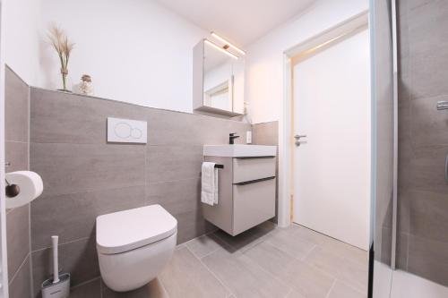 a bathroom with a white toilet and a sink at 247 Selfcheckin Pferdemarkt in Leer