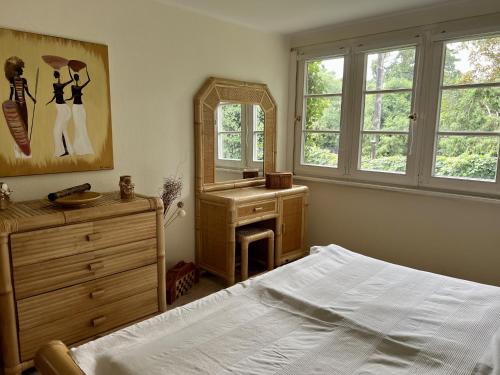 1 dormitorio con cama, tocador y espejo en Town meets Country, en Birkenwerder