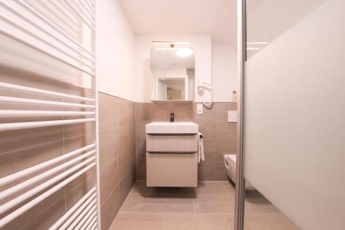 a bathroom with a sink and a mirror at 247 Selfcheckin Pferdemarkt in Leer