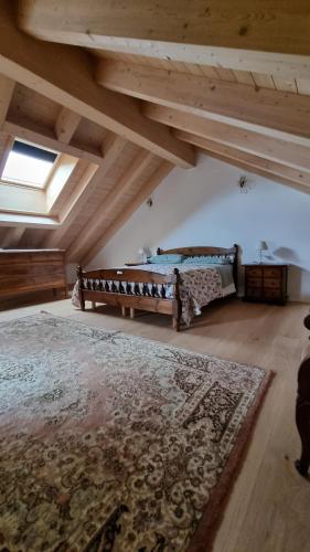 an attic room with two beds and a rug at Casa delle Orchidee in Feltre
