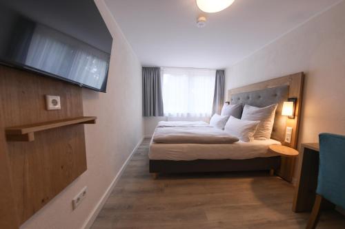 a hotel room with a bed and a television at 247 Selfcheckin Pferdemarkt in Leer