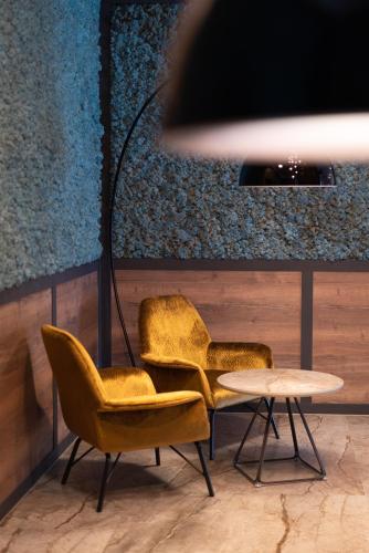 two chairs and a table in a room at Hotel Traunfall in Viecht