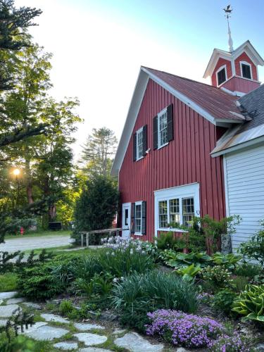 a red barn with a garden in front of it at Stone Hearth Inn and Eatery in Chester