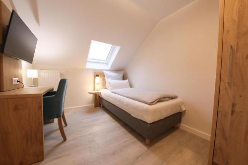 a bedroom with a bed with a desk and a window at 247 Selfcheckin Pferdemarkt in Leer