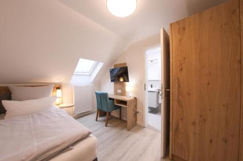 a bedroom with a bed and a desk with a computer at 247 Selfcheckin Pferdemarkt in Leer