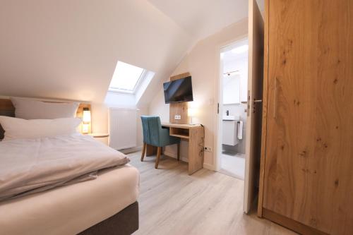 a bedroom with a bed and a desk with a television at 247 Selfcheckin Pferdemarkt in Leer
