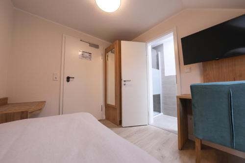a room with a bed and a flat screen tv at 247 Selfcheckin Pferdemarkt in Leer